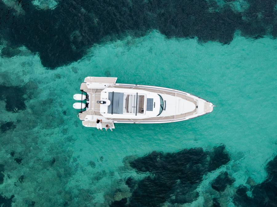 Aerial view of the boat anchored in a turquoise cove